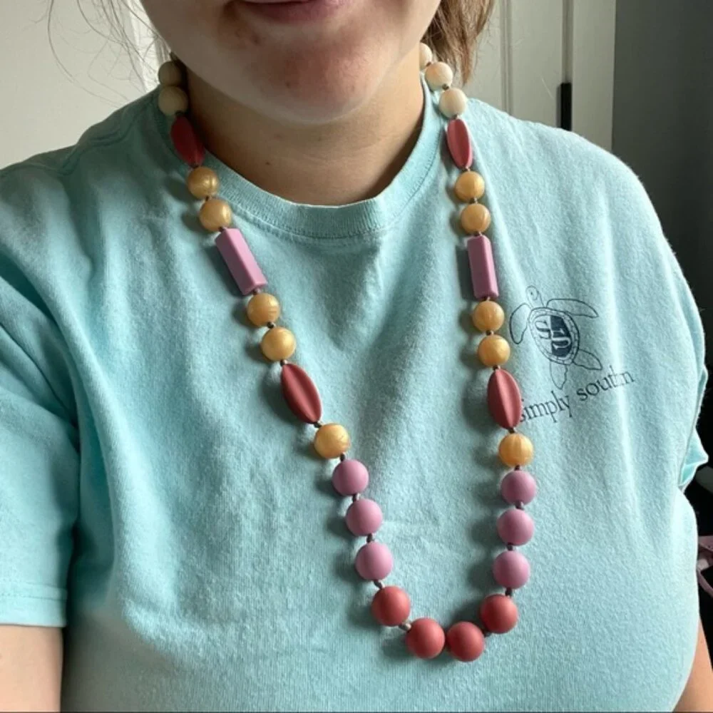 Itzy Ritzy | Teething Happens Chewable Mom Necklace | Pink & Gold